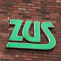 Zielone litery ZUS na ceglanej ścianie. Zastanawiasz się, jak długo jeszcze będziesz czekać na odpowiedź z ZUS?
