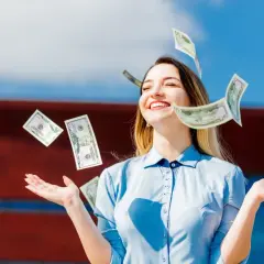 Szczęśliwa młoda kobieta rzuca banknotami, symbolizując sukces i wysokie zarobki z umowy zlecenia ze stawką godzinową.