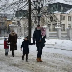 Rodzina spaceruje w zimowy dzień. Ojciec niesie córkę, a matka prowadzi syna. Może to właśnie oni skorzystają z 1000 zł na drugie dziecko?
