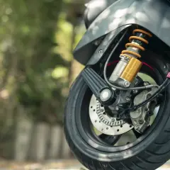 Szczegół przedniego koła motocykla z amortyzatorem, gotowego do podpisania umowy kupna sprzedaży motocykla.