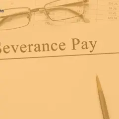 Okulary i długopis na dokumentach z napisem "Severance Pay", symbolizujące odprawę przy likwidacji stanowiska.