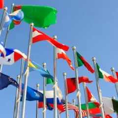 Wiele flag powiewa na wietrze na tle błękitnego nieba. Czy to symboliczne przedstawienie krajów, które oferują raj podatkowy?
