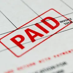 Czerwony stempel "PAID" na dokumencie, który może być fakturą zaliczkową a VAT.