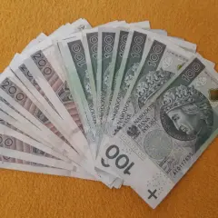 Stos banknotów 100 i 200 zł, gotowy na darowiznę dla dziecka.