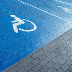 Niebieski parking dla osób z niepełnosprawnościami. Orzeczenie o niepełnosprawności można dostać na wiele chorób, np. ruchowych, wzroku, słuchu.
