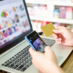 Osoba trzyma kartę płatniczą i telefon, przeglądając zakupy online. Rozważasz odstąpienie od umowy zawartej na odległość?