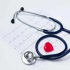 Stetoskop i czerwone serce na tle EKG. Zastanawiasz się, jak obliczyć dochód do składki zdrowotnej?