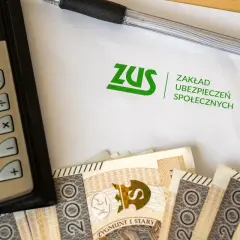 Kalkulator, długopis, dokument ZUS i polskie banknoty. Obrazek sugeruje rozważania: l4 na umowa zlecenie ile płatne?