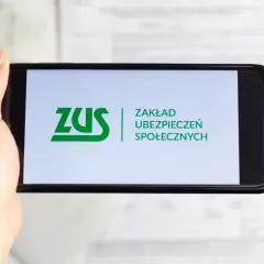 Dłoń trzyma smartfon z logo ZUS. Możliwe, że sprawdzasz zwrot składki zdrowotnej.