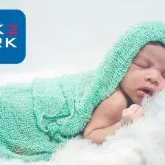 Śpiące dziecko otulone miętowym kocykiem. Logo Link2Work sugeruje, że becikowe jest dla kogoś z tej firmy.