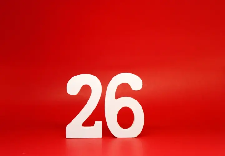 Białe cyfry 26 na czerwonym tle. Tyle dni urlopu zostało do wymarzonej podróży!