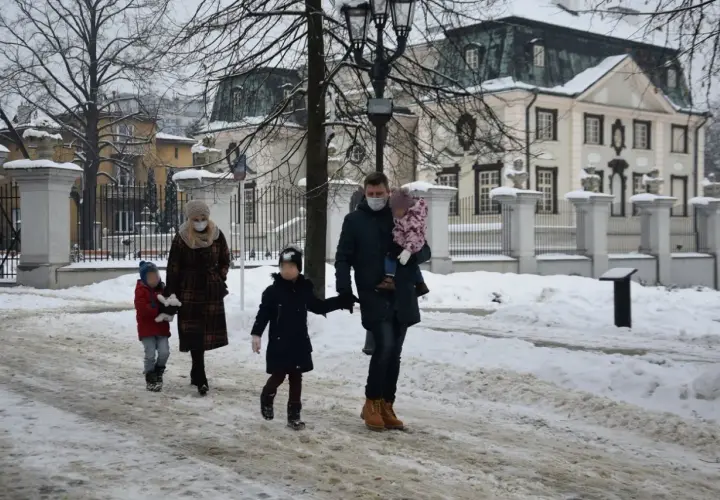 Rodzina spaceruje w zimowy dzień. Ojciec niesie córkę, a matka prowadzi syna. Może to właśnie oni skorzystają z 1000 zł na drugie dziecko?