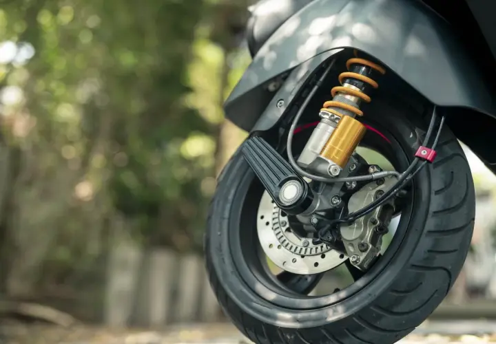 Szczegół przedniego koła motocykla z amortyzatorem, gotowego do podpisania umowy kupna sprzedaży motocykla.