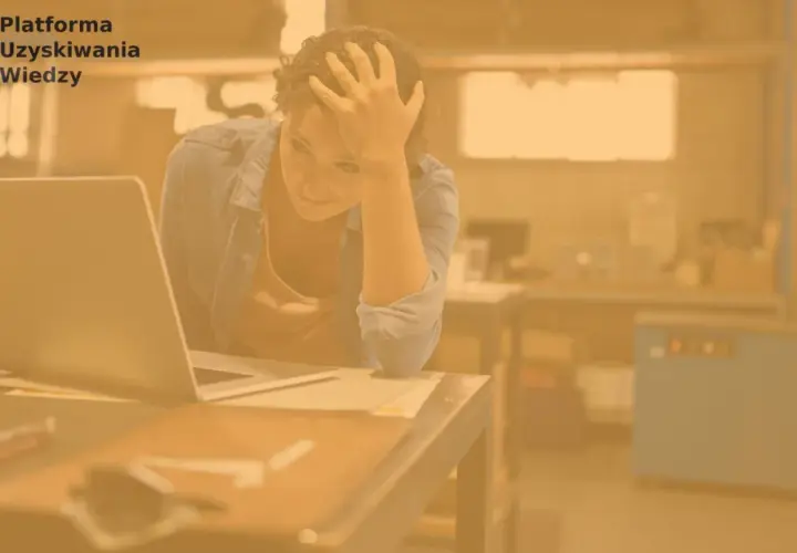 Zrezygnowana kobieta z ręką na czole siedzi przy laptopie. Szuka pracy, ale bezskutecznie.