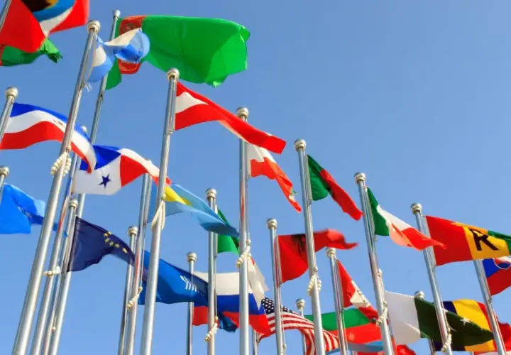 Wiele flag powiewa na wietrze na tle błękitnego nieba. Czy to symboliczne przedstawienie krajów, które oferują raj podatkowy?