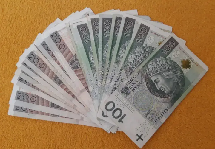 Stos banknotów 100 i 200 zł, gotowy na darowiznę dla dziecka.