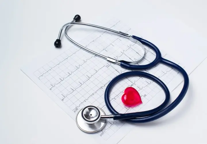 Stetoskop i czerwone serce na tle EKG. Zastanawiasz się, jak obliczyć dochód do składki zdrowotnej?