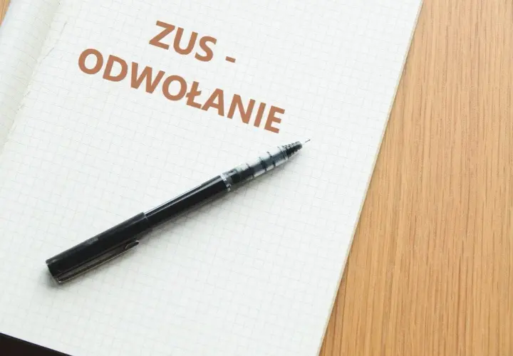 Notatnik z napisem "ZUS - ODWOŁANIE" i długopisem. Dowiedz się, jak napisać odwołanie od decyzji ZUS.