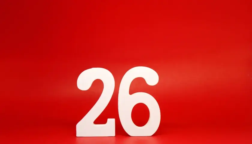 Białe cyfry 26 na czerwonym tle. Tyle dni urlopu zostało do wymarzonej podróży!
