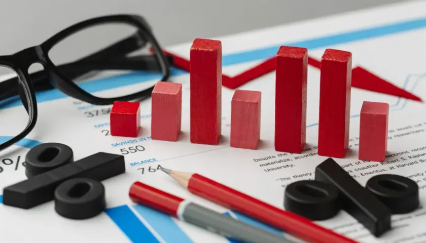 Analiza finansowa, wykresy i procenty symbolizują planowanie przekształcenia JDG w spółkę zoo. Okulary i ołówki sugerują strategiczne myślenie.