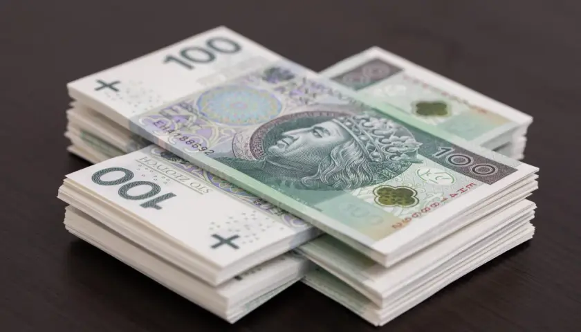 Stosy banknotów 100 zł. Wartość gotówki może być ograniczona, ale te pieniądze wyglądają na gotowe do wydania.