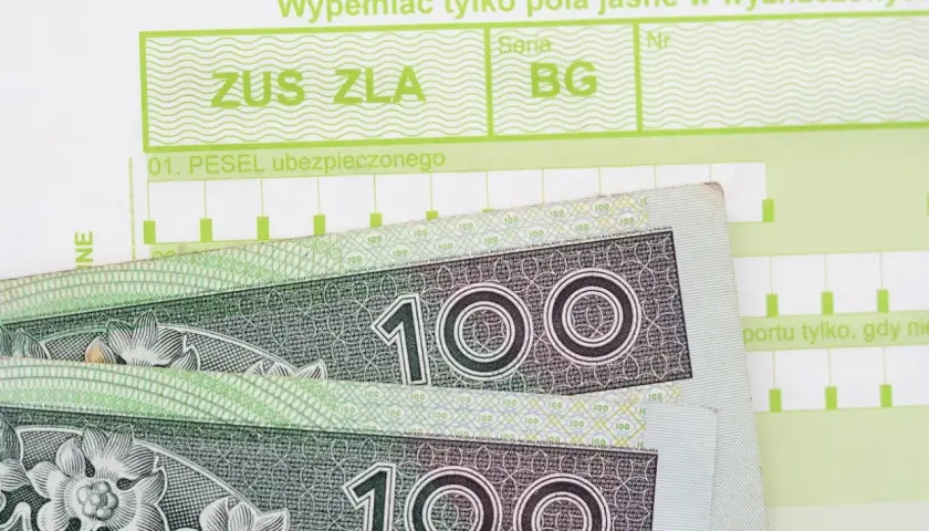 Formularz ZUS ZLA i banknoty 100 zł. Pytanie: ile wynosi zasiłek chorobowy?