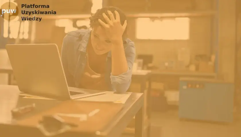 Zrezygnowana kobieta z ręką na czole siedzi przy laptopie. Szuka pracy, ale bezskutecznie.