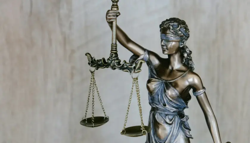 Figurka Temidy z wagą, symbol sprawiedliwości i siła wyższa powody.