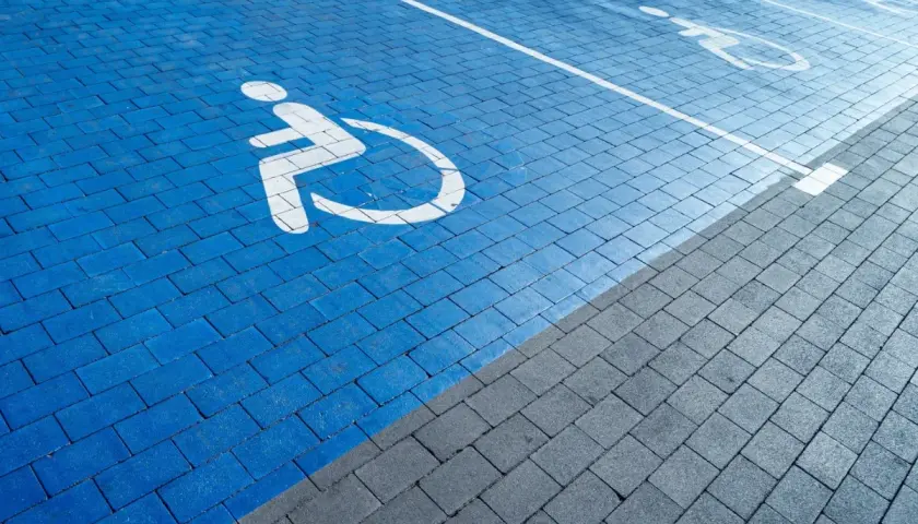Niebieski parking dla osób z niepełnosprawnościami. Orzeczenie o niepełnosprawności można dostać na wiele chorób, np. ruchowych, wzroku, słuchu.
