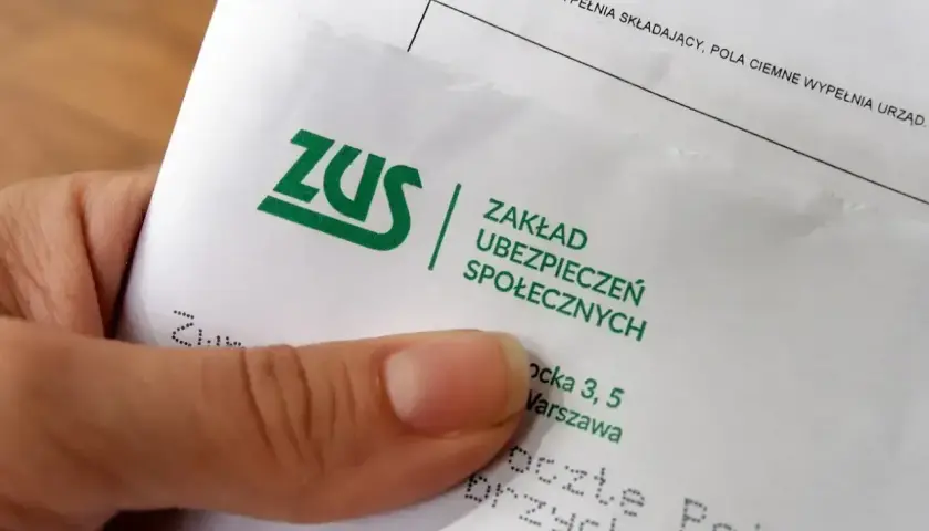Dłoń trzyma dokument ZUS. Warto sprawdzić, ile wynosi odprawa emerytalna, by mieć pewność co do przyszłości.