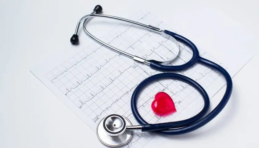 Stetoskop i czerwone serce na tle EKG. Zastanawiasz się, jak obliczyć dochód do składki zdrowotnej?