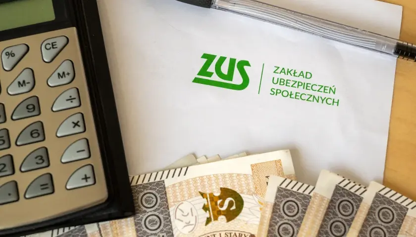 Kalkulator, długopis, dokument ZUS i polskie banknoty. Obrazek sugeruje rozważania: l4 na umowa zlecenie ile płatne?