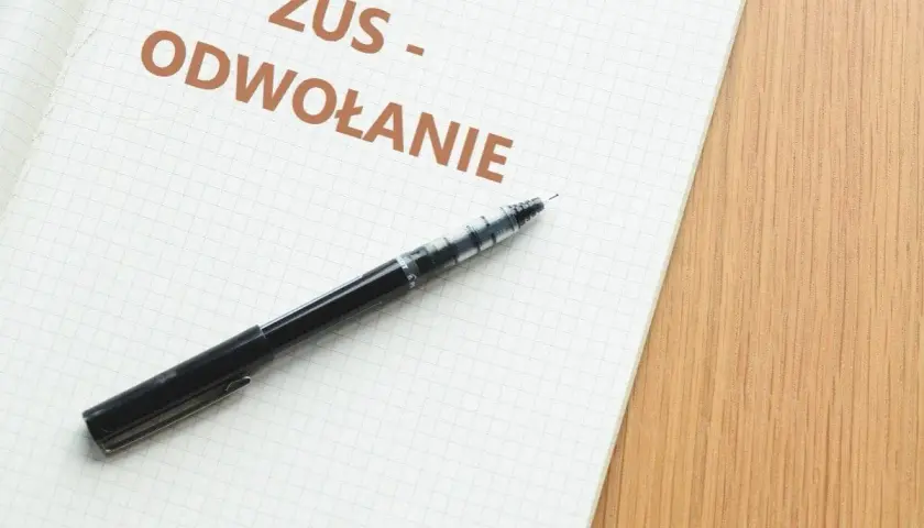 Notatnik z napisem "ZUS - ODWOŁANIE" i długopisem. Dowiedz się, jak napisać odwołanie od decyzji ZUS.