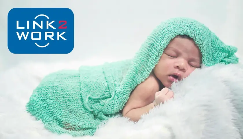 Śpiące dziecko otulone miętowym kocykiem. Logo Link2Work sugeruje, że becikowe jest dla kogoś z tej firmy.