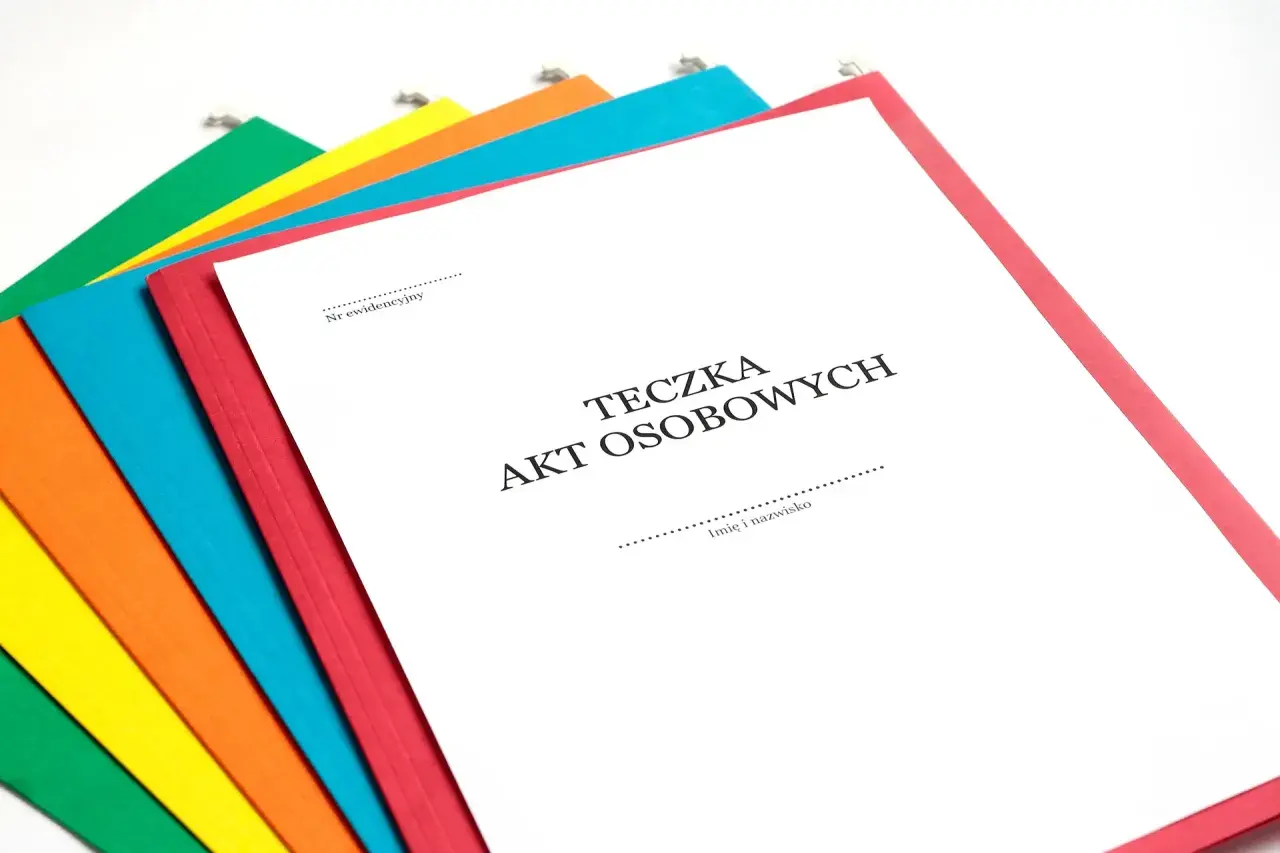 Kolorowe teczki z dokumentami, jedna z nich to Teczka Akt Osobowych.