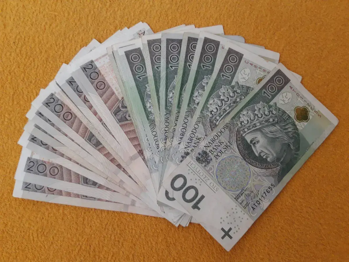 Stos banknotów 100 i 200 zł, gotowy na darowiznę dla dziecka.