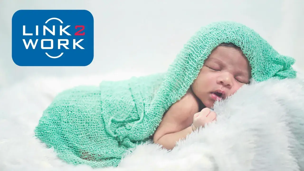 Śpiące dziecko otulone miętowym kocykiem. Logo Link2Work sugeruje, że becikowe jest dla kogoś z tej firmy.
