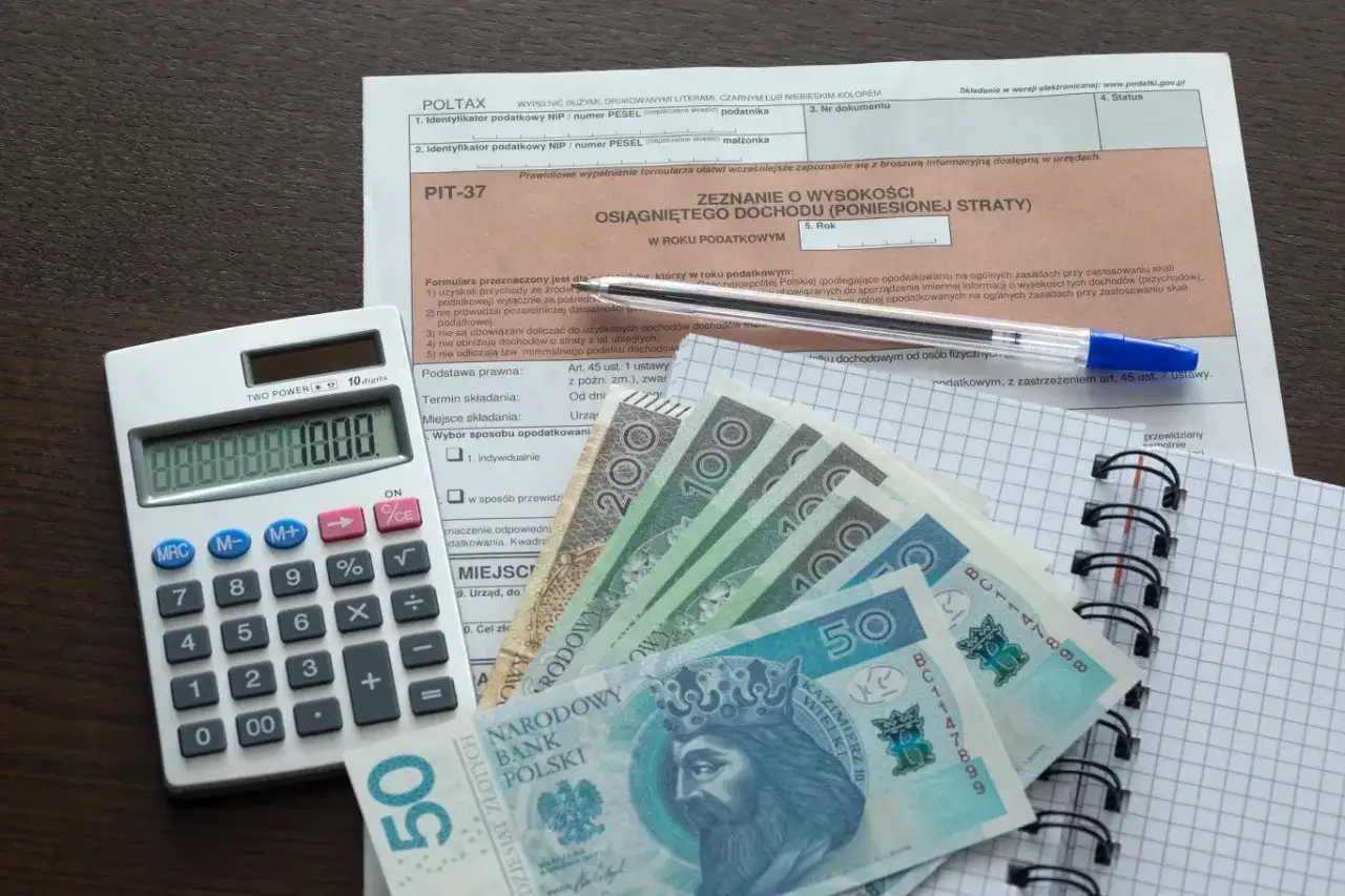 Formularz PIT-37, kalkulator, polskie banknoty i długopis. Możliwe odliczenie lek&oacute;w od podatku.