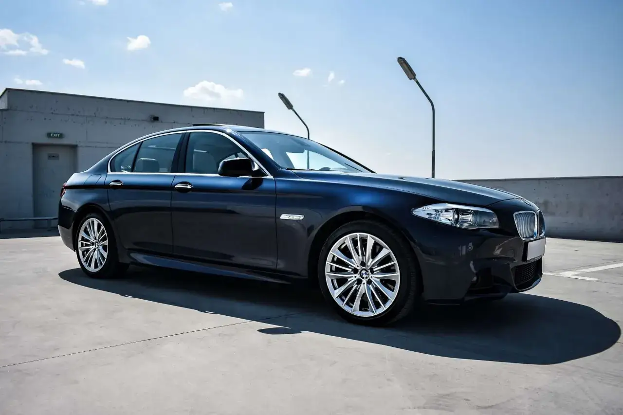 Ciemnoniebieskie BMW na parkingu. Marzysz o wykupie auta z leasingu? Ten elegancki sedan może być Tw&oacute;j!