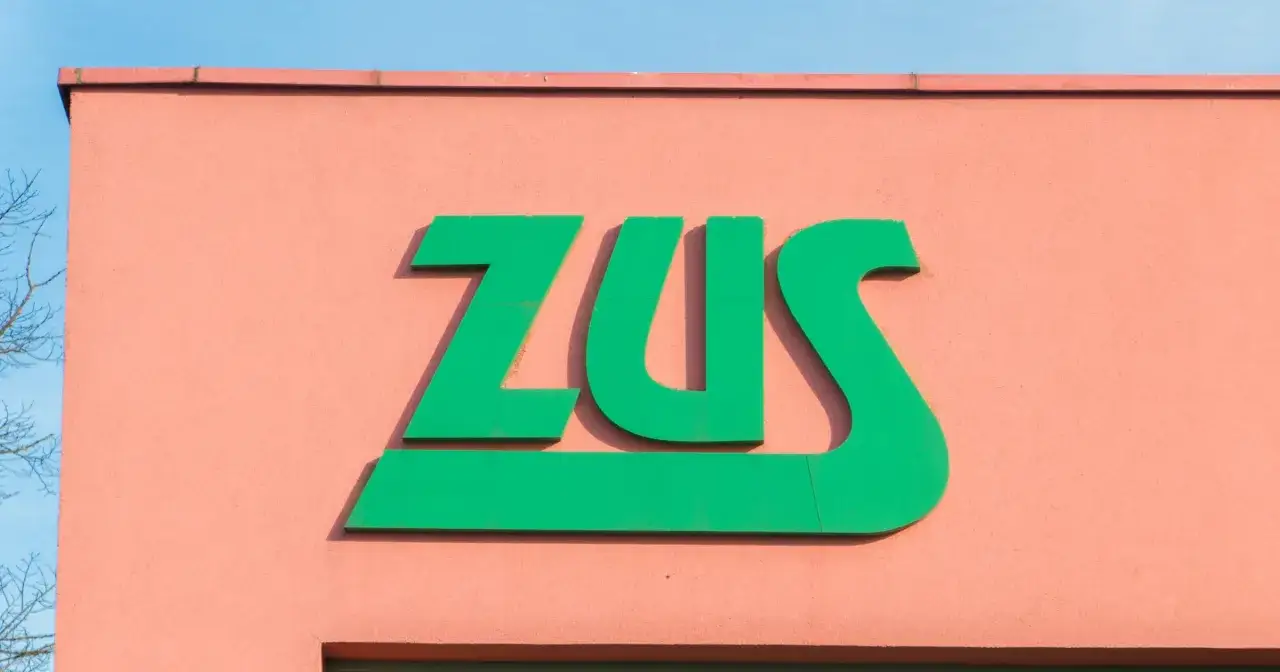Zielone logo ZUS na różowej ścianie. Zastanawiasz się, ile można być na zwolnieniu lekarskim od psychiatry?