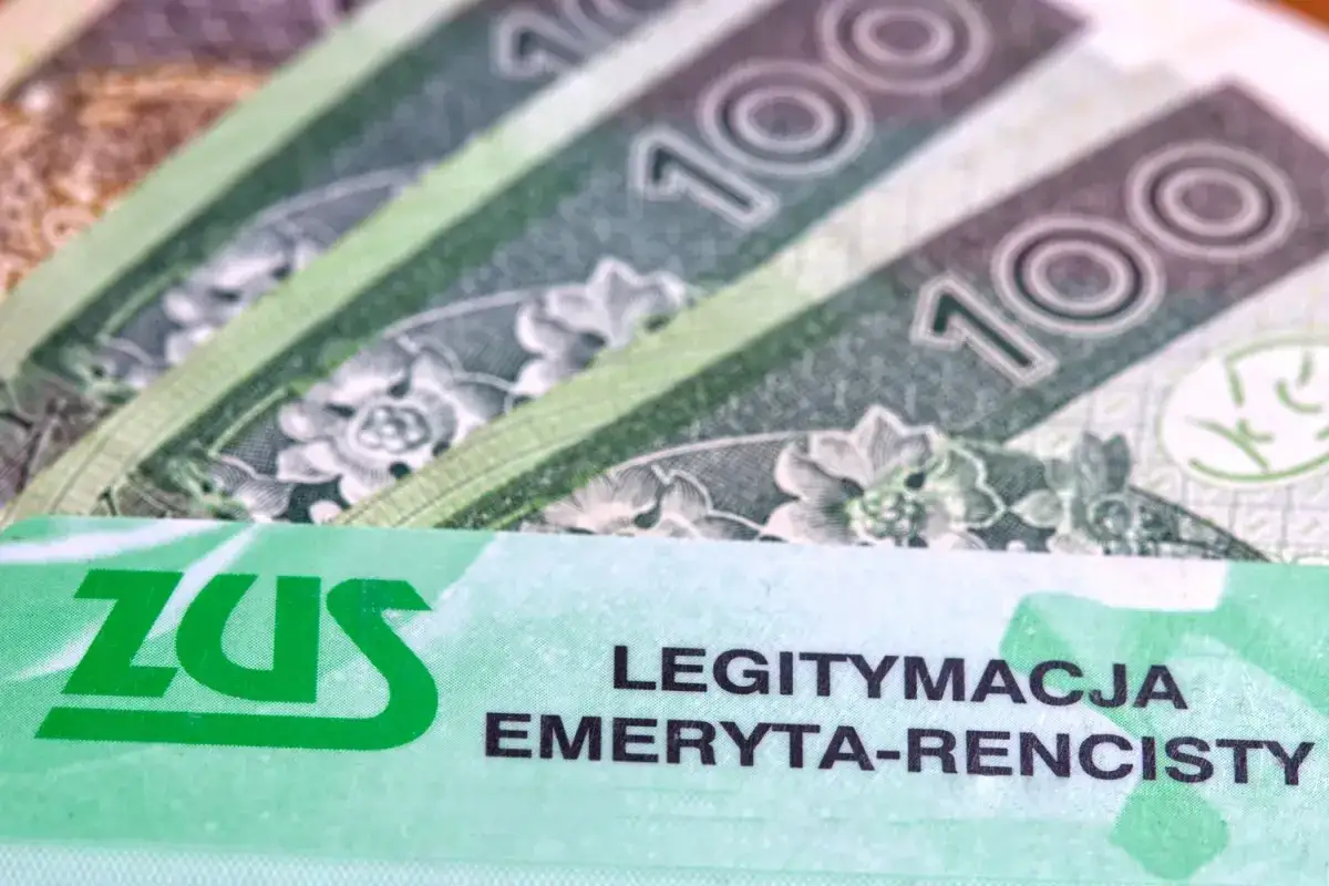 ZUS legitymacja emeryta-rencisty na tle banknotów 100 zł. Nowe przepisy dotyczące emerytur stażowych do końca roku.